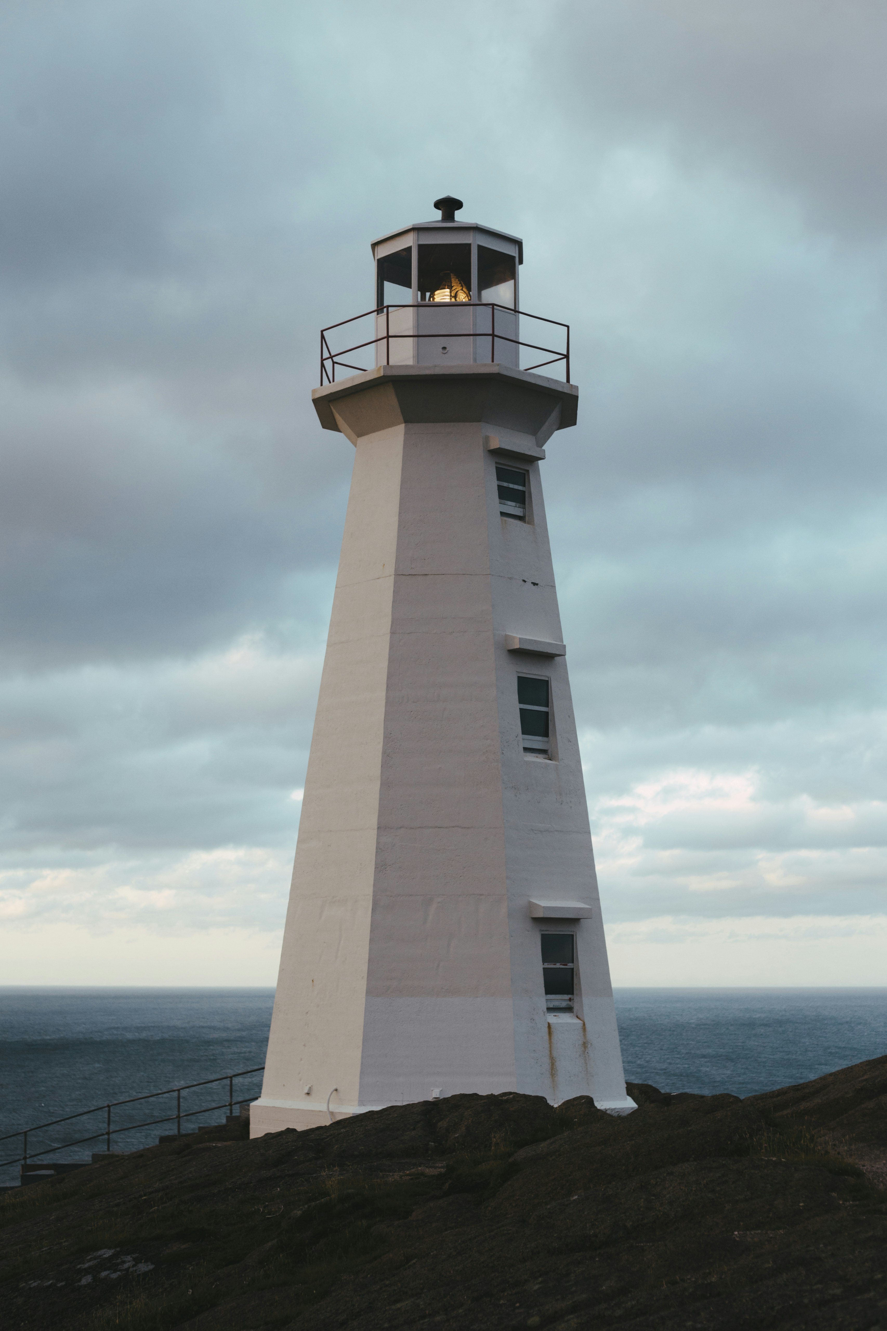 white and black lighthouse near body of water during daytime